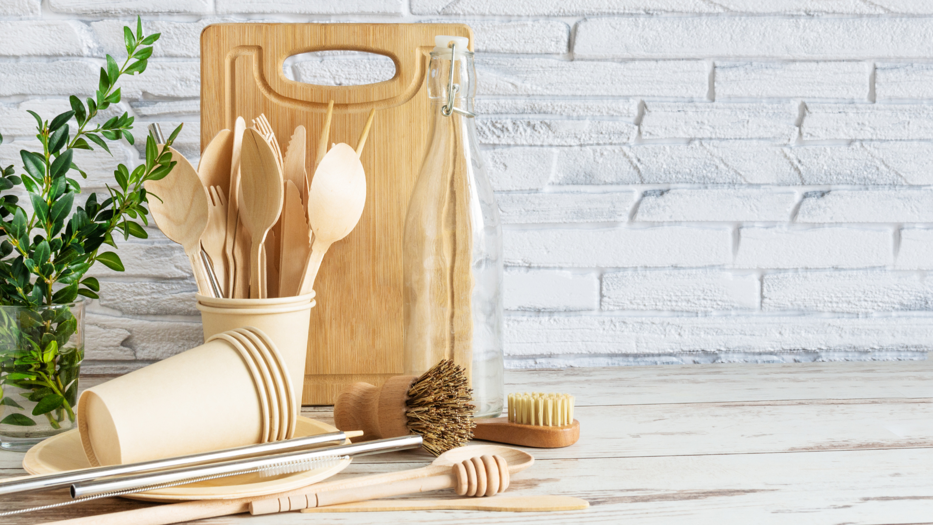 Eco-friendly kitchen setup with compostable cups, wooden cutlery, and reusable utensils for a plastic-free foodservice operation.